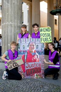 4 Mitarbeiter:innen von Germanwatch mit einem großen Bild von Saúl Luciano Lliuya und einem Schild mit der Aufschrift #End Fossil Fuels