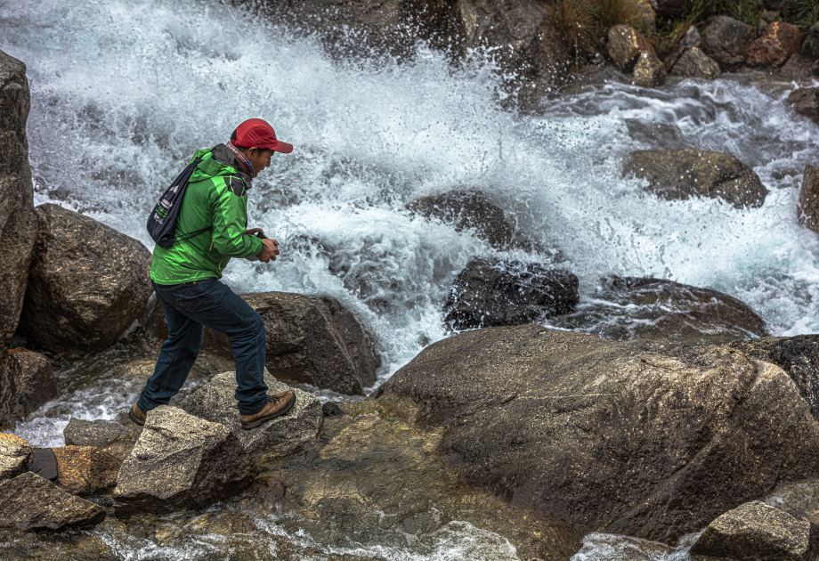 Saúl vor reißendem Fluss Saúl läuft auf Steinen vor einem reißenden Fluss
