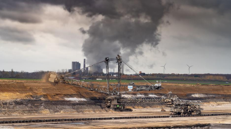 Schaufelradbagger von RWE im Braunkohletagebau mit Kraftwerk im Hintergrund