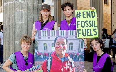 4 Mitarbeiter:innen von Germanwatch mit einem großen Bild von Saúl Luciano Lliuya und einem Schild mit der Aufschrift #End Fossil Fuels